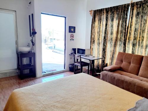 a bedroom with a bed and a couch and a table at Suite amplia privada a 8 min del centro in Aguascalientes