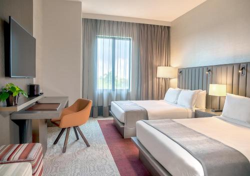 una camera d'albergo con 2 letti e una scrivania di THesis Hotel Miami a Miami
