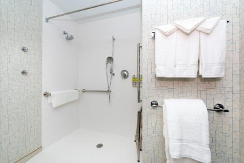 a bathroom with a shower with white towels at Holiday Inn Express & Suites - Romeoville - Joliet North, an IHG Hotel in Romeoville