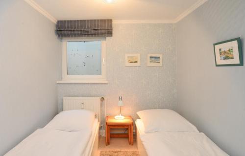 - 2 lits dans une chambre avec une table et une fenêtre dans l'établissement Fesker-4, à Morsum