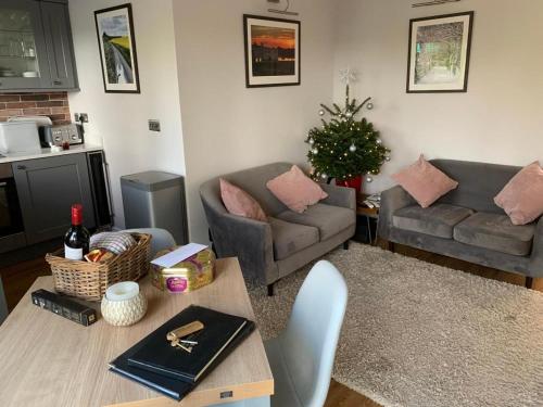a living room with two couches and a christmas tree at Northdown Lodge - Stunning property on the Kent Northdowns in Hollingbourne