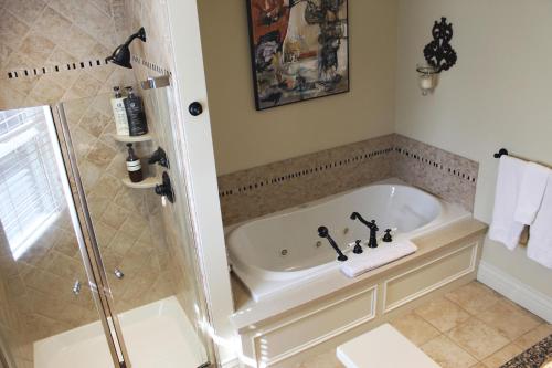 a bathroom with a bath tub and a shower at Norfolk Guest House Inn in Guelph