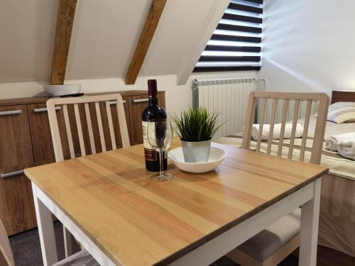 a table with a bottle of wine and a glass at Snow White apartments in Kopaonik