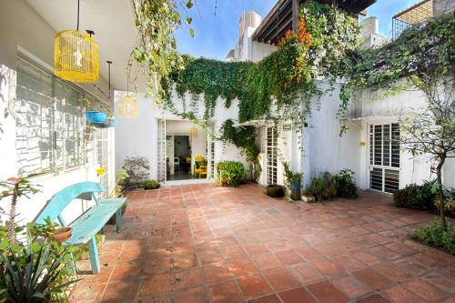 a patio with a blue bench and a white house at Casa Canario Hostel in Guadalajara