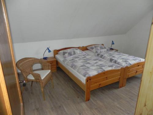 ein Schlafzimmer mit einem Holzbett und einem Stuhl in der Unterkunft sonja in Ditzum