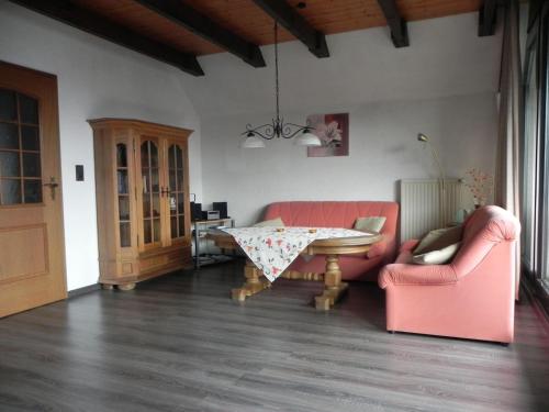 a living room with two pink chairs and a table at sonja in Ditzum