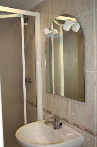 a bathroom with a sink and a mirror at Hotel la Masia in Portbou