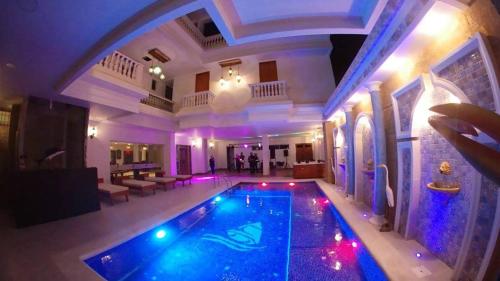 a swimming pool in a house with purple lights at Hotel Boutique Campanario del Río in Soledad