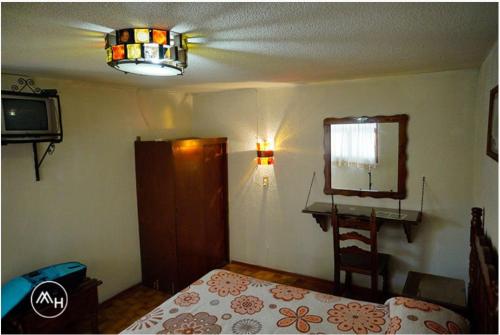 a bedroom with a bed and a mirror and a lamp at Hotel Atilanos in Morelia