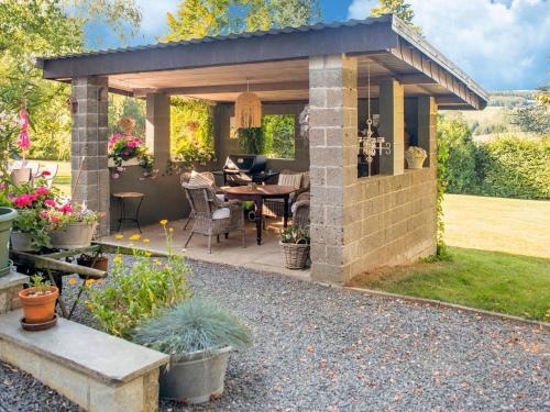 een paviljoen met een tafel en stoelen in een tuin bij Luring Holiday Home in Lierneux with Garden in Lierneux