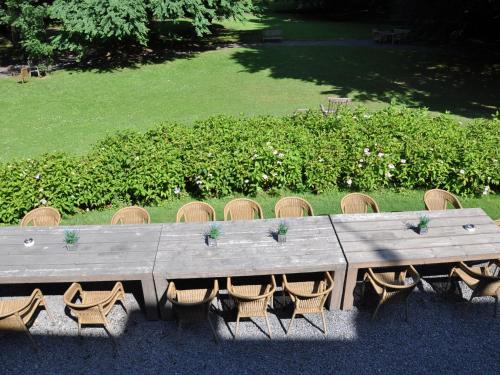 una larga mesa de madera con sillas y un campo en Beautiful castle house in Spa with spacious garden, en Spa
