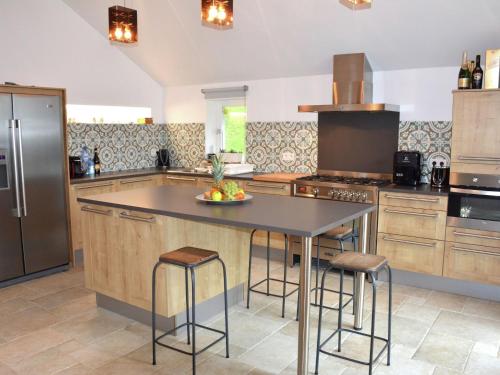 ストゥモンにあるStately Chalet in Stoumont with Pool Saunaのバースツール付きの大きな島のあるキッチンが備わります。