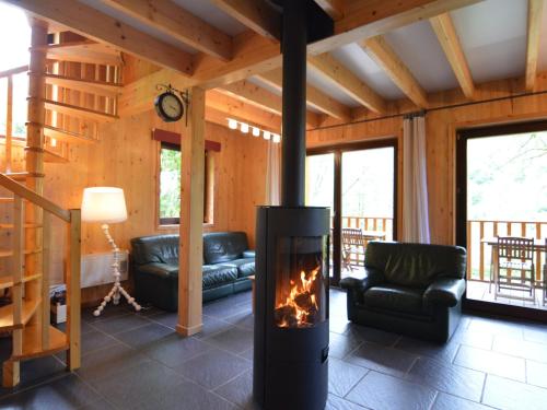 a living room with a fireplace in a cabin at Comfortable modern chalet with wood finish in Aywaille