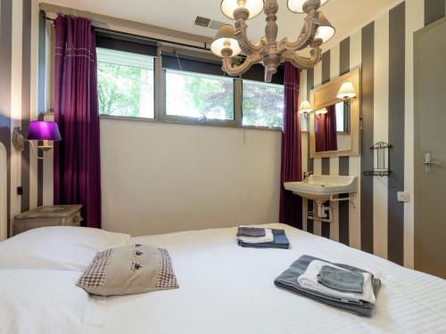 - une chambre avec un lit, un lavabo et un lustre dans l'établissement Luxurious Holiday Home near Forest in Malmedy, à Longfaye