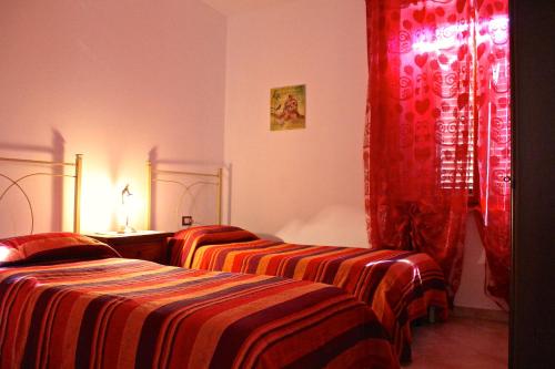 a hotel room with two beds and red curtains at Casa Vacanze Ribocchi in Campiglia Marittima