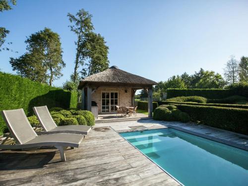 ogród z basenem, 2 krzesłami i altaną w obiekcie Classy Holiday Home in Aartrijke with Private Swimming Pool w mieście Aartrijke
