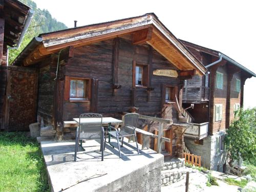 a cabin with a table and chairs in front of it at wooden chalet in Betten near the Aletsch Arena in Betten