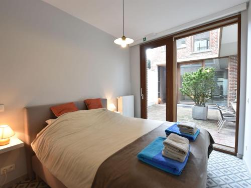 1 dormitorio con 1 cama grande y toallas azules. en Studio in Ieper with terrace en Ypres