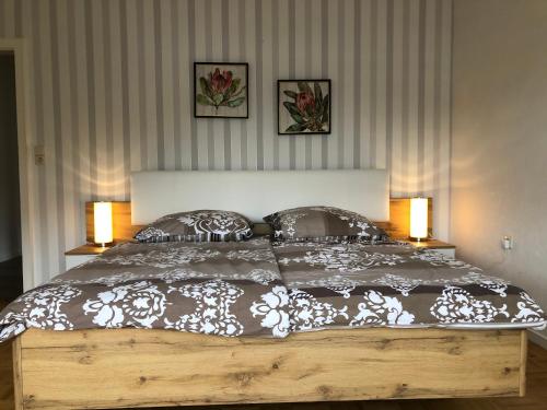a bedroom with a large bed with two lamps at Gästehaus Alm-Blick in Murrhardt