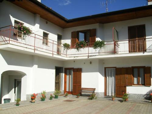 a white building with balconies and a bench on it at Il Barucin in Villar San Costanzo