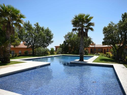 - une piscine dans une cour avec des palmiers dans l'établissement Belvilla by OYO Mirador Mas Nou, à Castillo de Aro