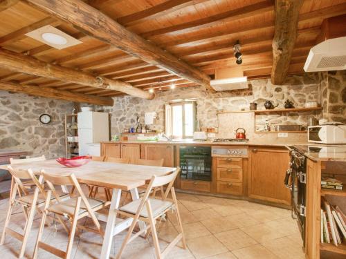 a kitchen with a wooden table and chairs at Belvilla by OYO Casa Ribeira Sacra in Castillón