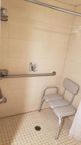 a chair in a bathroom with a towel at Royal Century Hotel at LAX in Inglewood