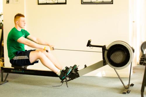 a man sitting on a reformer in a gym at The Keadeen Hotel in Newbridge