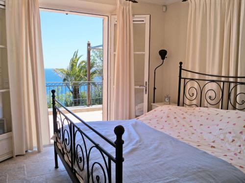 une chambre avec un lit avec vue sur l'océan dans l'établissement Villa in Anthéor with Pool & Beach Views, à Saint-Raphaël