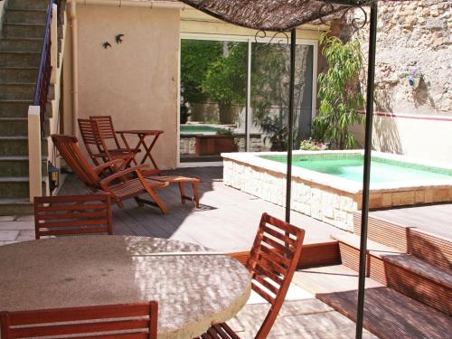 モンタニャックにあるAttractive holiday home with swimming poolのパティオ(テーブル、椅子付)、スイミングプールが備わります。
