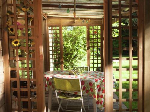 a table in a screened in porch with a table and chairs at Lovely Holiday Home in Le Ponchel with Garden Pond in Le Ponchel