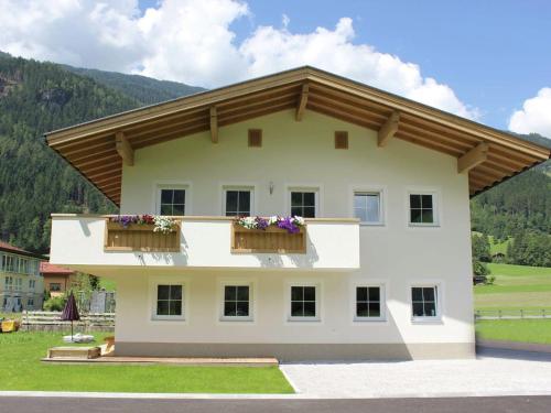アシャウにあるApartment near ski area in Aschau in Tyrolのバルコニー2つと花が咲く建物