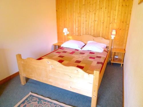 een slaapkamer met een houten bed in een kamer bij The ideal chalet for a relaxing holiday in the mountains in Celliers