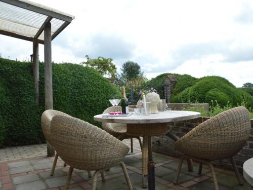 een tafel en stoelen op een patio bij stylish holiday home in Rijsberge