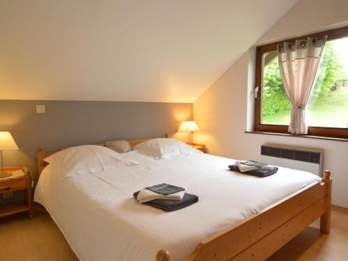 um quarto com uma grande cama branca e uma janela em Contemporary Chalet in Malmedy near Forest em Malmedy