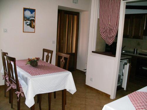 ein Esszimmer mit einem Tisch und einer Küche in der Unterkunft Il Barucin in Villar San Costanzo