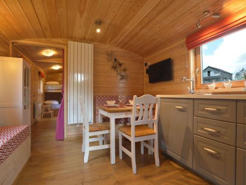 a kitchen with a table and chairs in a cabin at Charming Holiday Home in Malmedy with Sauna in Malmedy