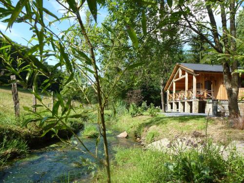 una casa en el bosque con un río delante en Majestic Chalet in Arville with Bubble Bath, en Smuid