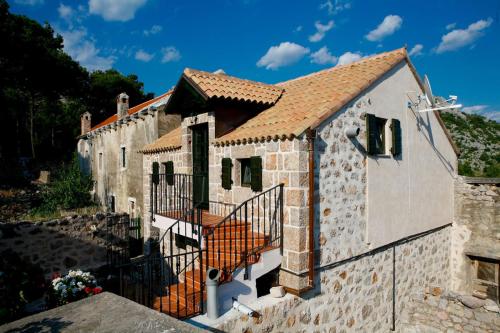 an external view of a stone house with a gate at Stein House Marasovic in Starigrad