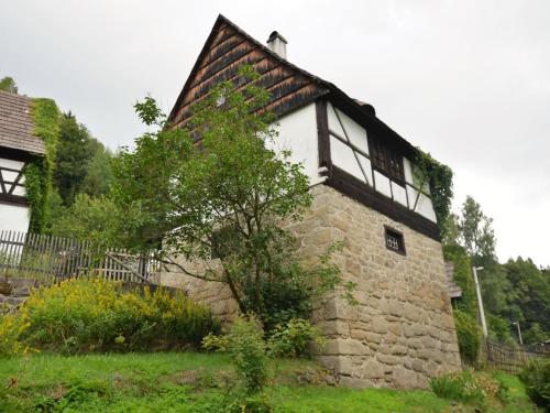 內耶德克的住宿－Holiday Home in Nejdek in West Bohemia with garden，一座古老的石头建筑,前面有一棵树