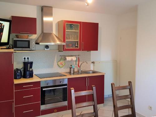 a kitchen with red cabinets and a sink and two chairs at Ostsee 1 in Zierow