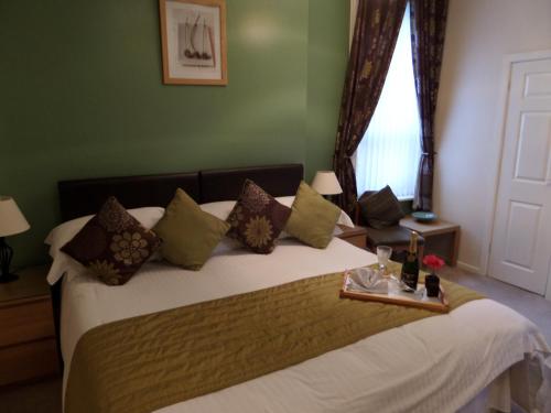 een slaapkamer met een groot bed en een dienblad bij The Grays in Blackpool