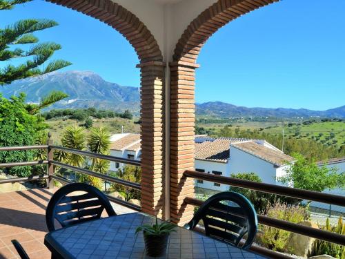 patio con mesa y sillas en el balcón en Belvilla by OYO Casas Rurales Huetor, en Viñuela