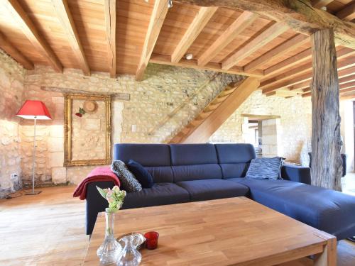 a living room with a blue couch and a wooden table at Holiday home with pool in Verteillac in Verteillac