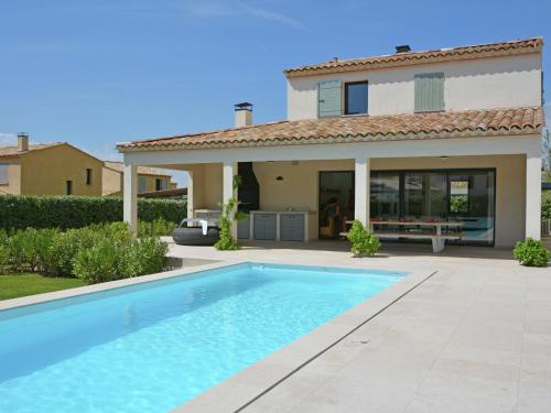 a swimming pool in front of a house at Vibrant Villa in Malauc ne with Private Garden in Malaucène