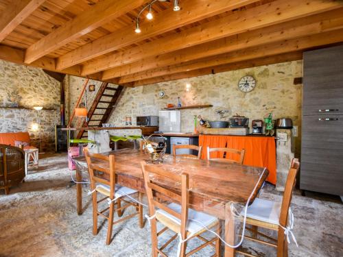 une cuisine et une salle à manger avec une table et des chaises en bois dans l'établissement Cottage in Aquitaine with Bubble Bath, à Monprimblanc
