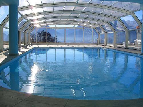 une grande piscine avec un plafond en verre dans l'établissement Belvilla by OYO Villa Stenico, à Stenico