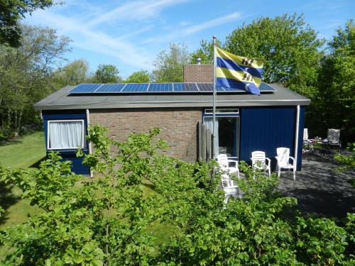 ネスにあるDetached bungalow in Nes on Ameland with spacious terraceの青屋根の家