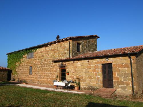 - un ancien bâtiment en pierre avec une table devant dans l'établissement Belvilla by OYO Piano, à Sorano