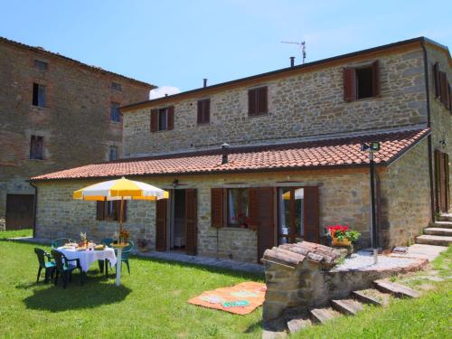 a table with an umbrella in front of a building at Belvilla by OYO Rosa Cremisi in Apecchio